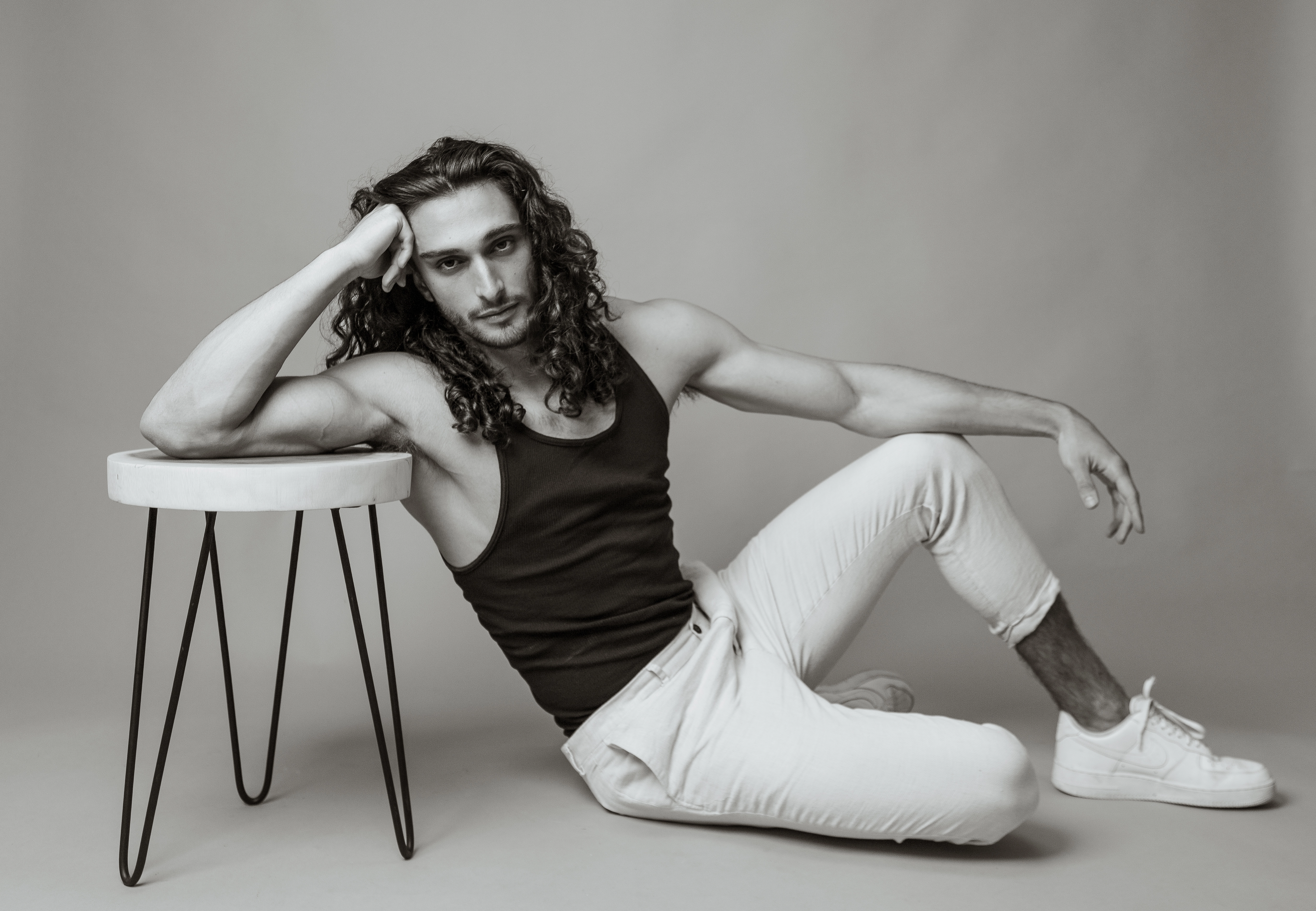 Full-body black and white shot of model laying on the ground